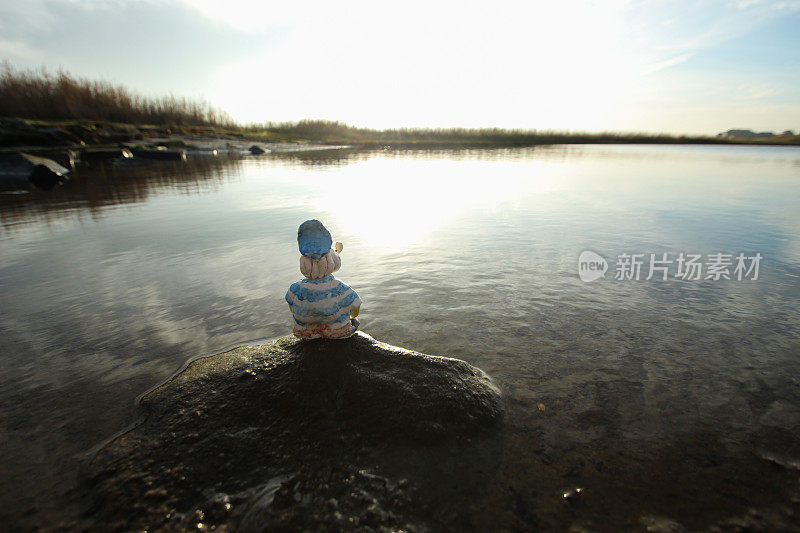 水手在湖边的岩石上享受宁静的时刻