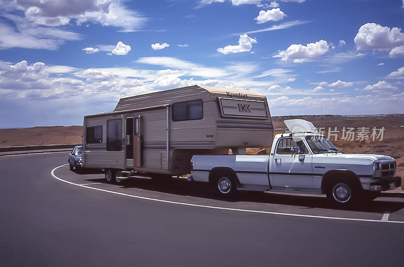 在美国西部的道路上，由小货车拉动的房车。