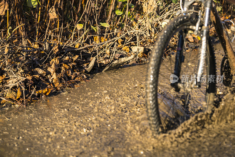 在泥泞中骑自行车，溅满了水珠。