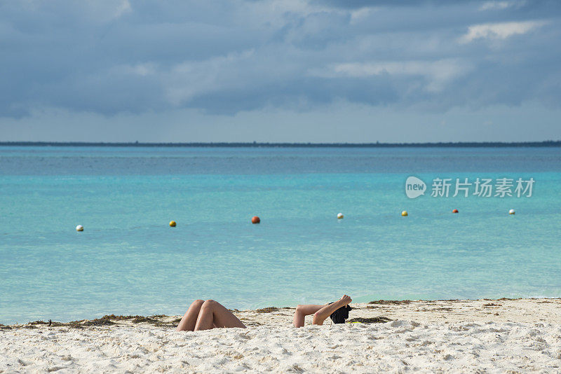 在海滩上晒太阳的人的胳膊和腿