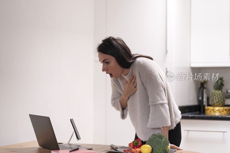 失望而悲伤的女人正在家里看她的笔记本电脑