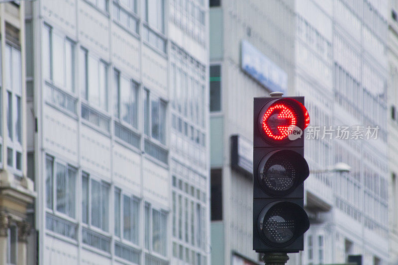 城市街道上的红灯和带有商场的公寓楼。