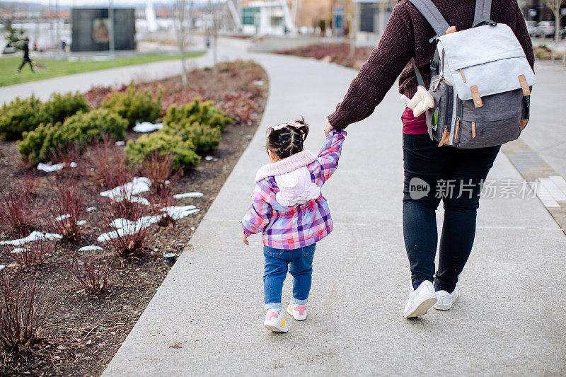 西班牙母亲和女婴在公园散步