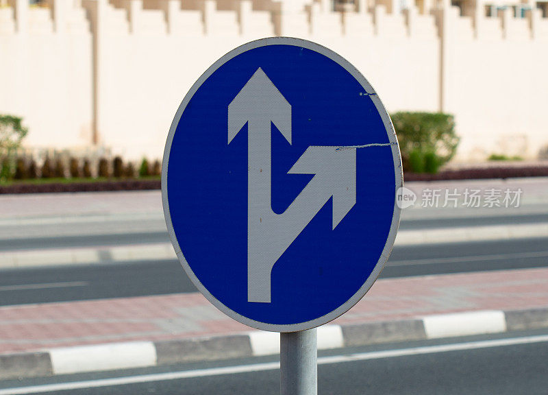 道路上蓝色交通标志上的白色箭头引导交通。