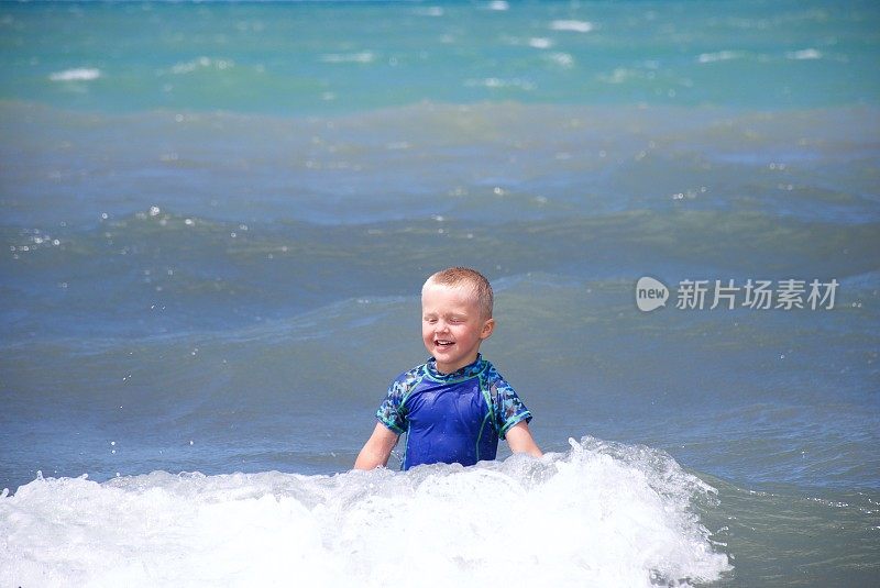 夏天在海里划船的小男孩