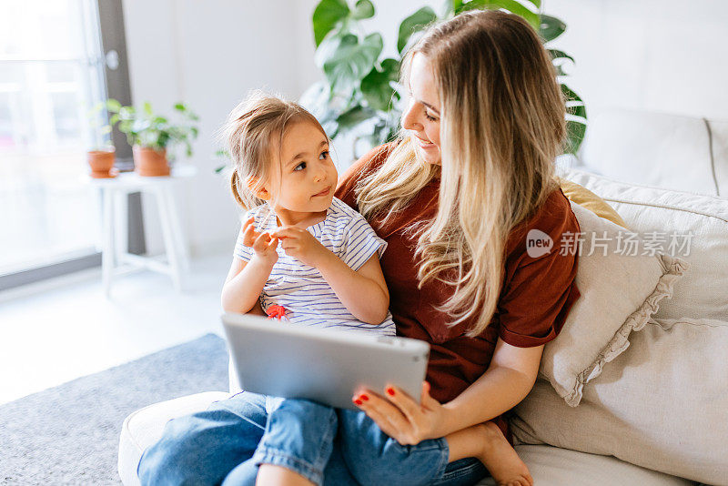 母亲和女儿一起使用电子平板电脑
