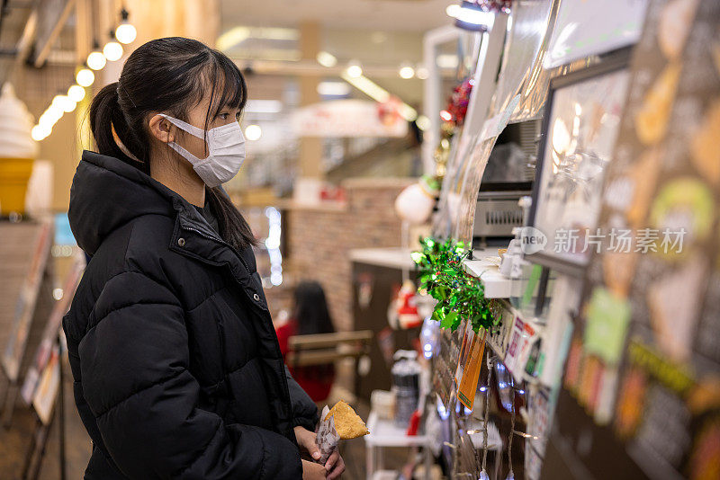 十几岁的女孩在购物中心点饮料