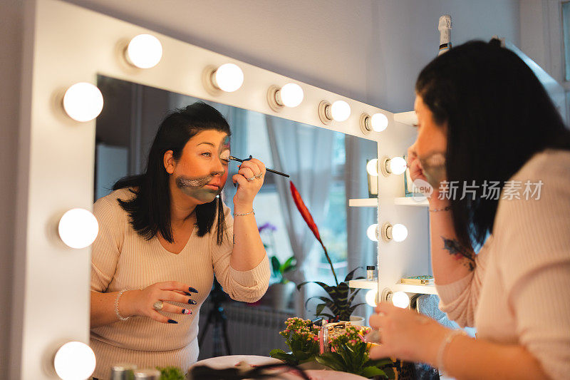 女化妆师在镜子前为万圣节化妆