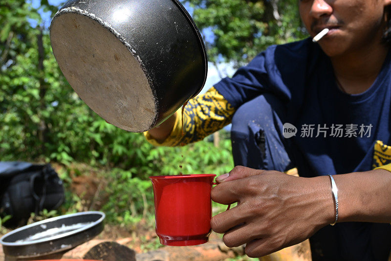 男人往杯子里倒咖啡的照片