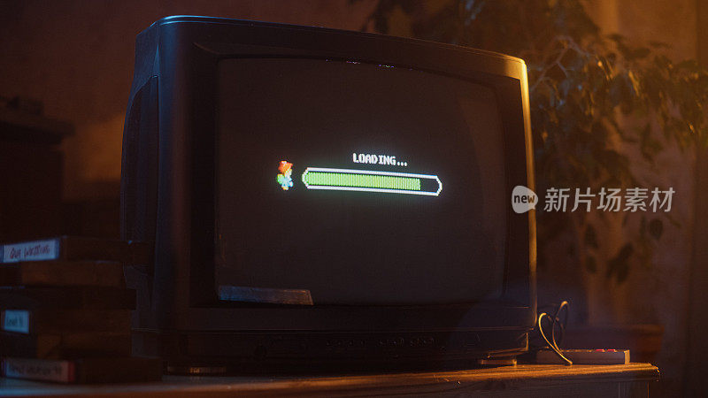 近距离镜头的复古电视机屏幕与八位八十年代启发游戏机街机视频游戏。任务加载，玩家等待开始一个新的更难的关卡。绿色进度条正在移动。