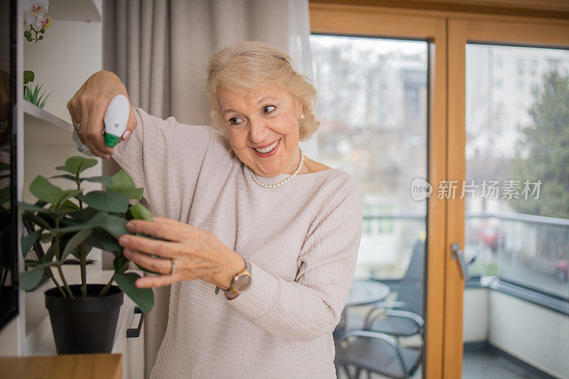 一位老年妇女在她的新公寓里照料植物