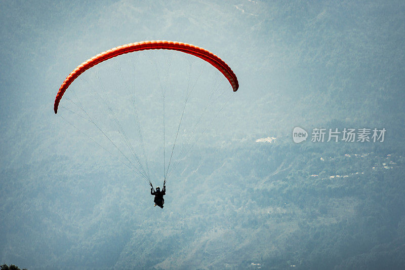 滑翔伞飞过城镇和山脉。
