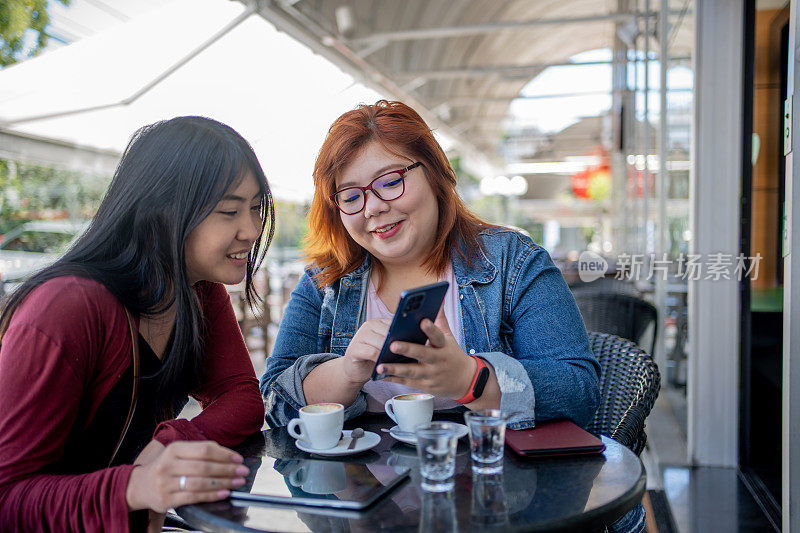 日本女性朋友在咖啡馆使用智能手机