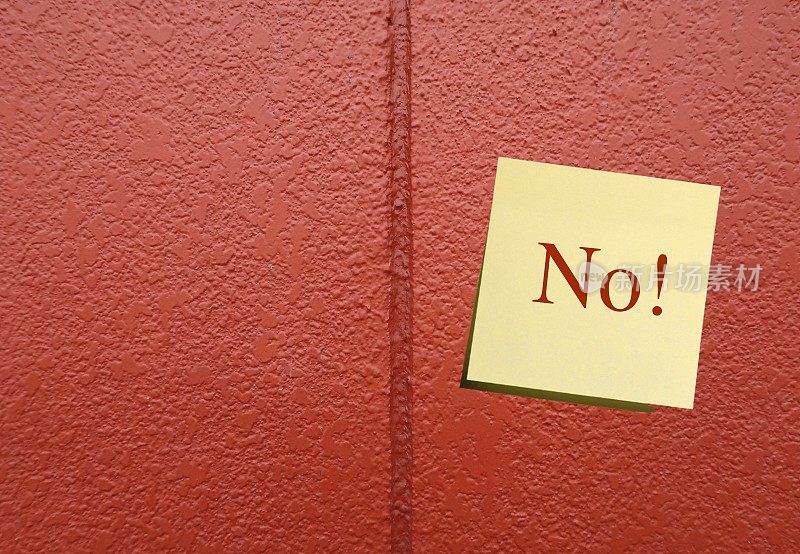 在橙色墙壁背景上粘贴文字NO!在美国，人们为了取悦别人而说“是”的观念可以变得更加自信——做出改变，学会说他们真正想说的“不”