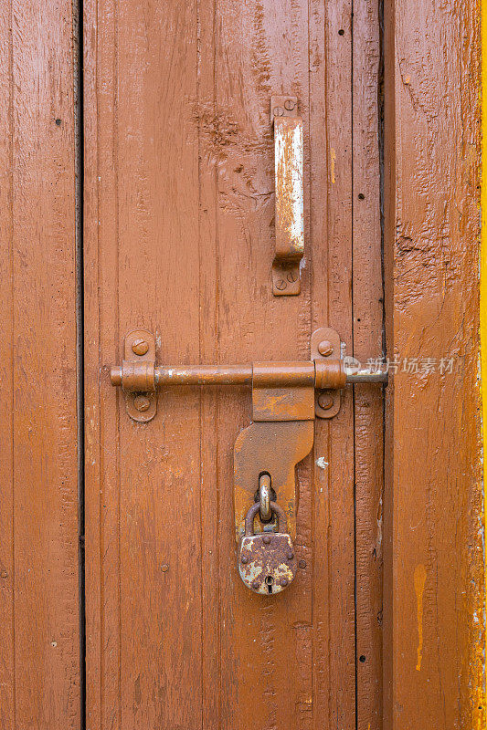 一扇旧木门上生锈的挂锁