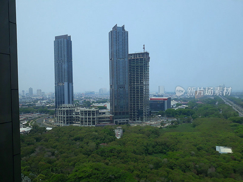 高角度观看雅加达印尼城市景观与塔式建筑，公路街道和绿色公园