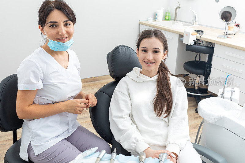 正畸医生检查女性牙齿的托槽。口腔科、牙科、牙套正畸治疗的概念