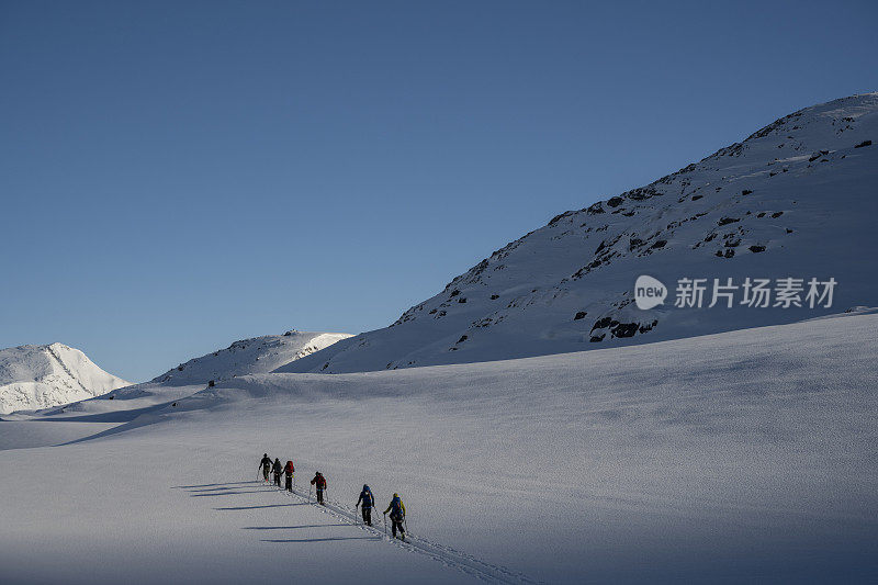 滑雪登山运动员攀登白雪皑皑的山峰