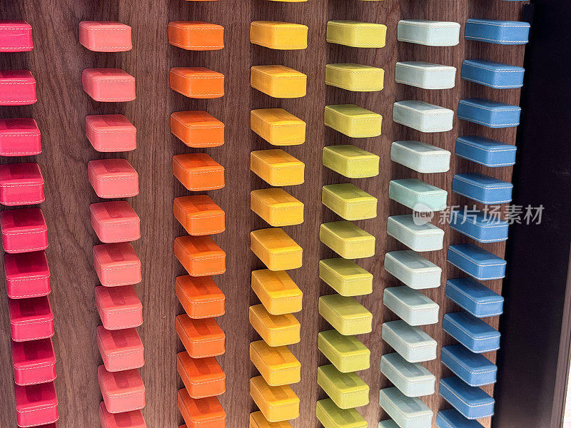 彩色矩形块的彩色图表的特写图像，列和行，紫色，粉红色，橙色，黄色，绿色和蓝色的渐变在木墙上，木纹背景，重点在前景