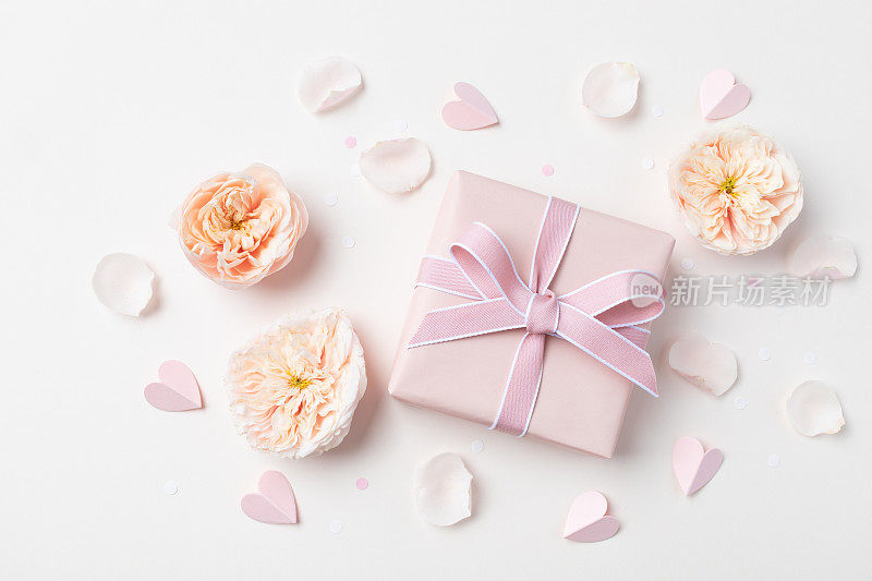 生日，女人或母亲节贺卡。粉红色的心，玫瑰花和礼盒在柔和的桌面视图。平的。