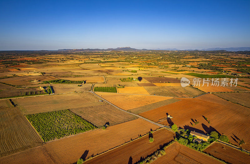 从热气球鸟瞰西班牙马略卡岛巴利阿里岛上马纳科尔和费拉尼克斯之间的郊区和农业用地