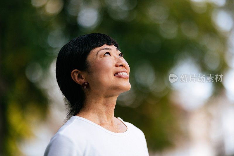 微笑的女人在城市公园里享受新鲜空气