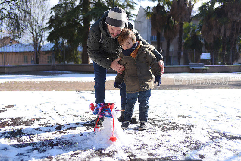 父亲和儿子在堆雪人