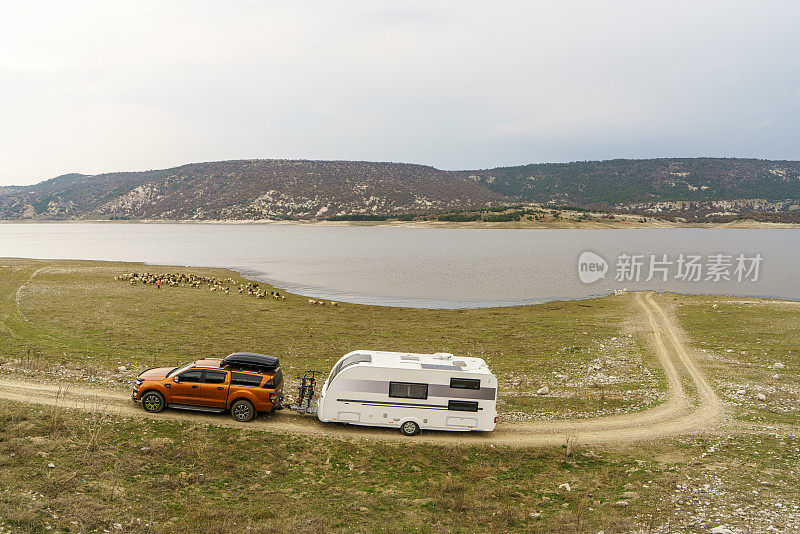 在土耳其安纳托利亚湖附近的乡村道路上，一辆皮卡拉着一辆拖车