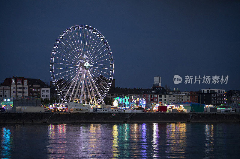 夜河上，灯火通明的大车轮和露天广场