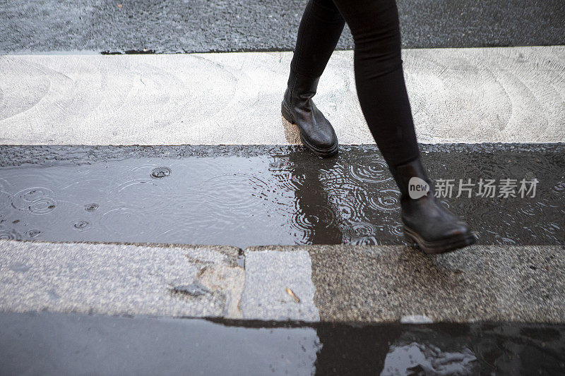 雨中走过斑马线的人