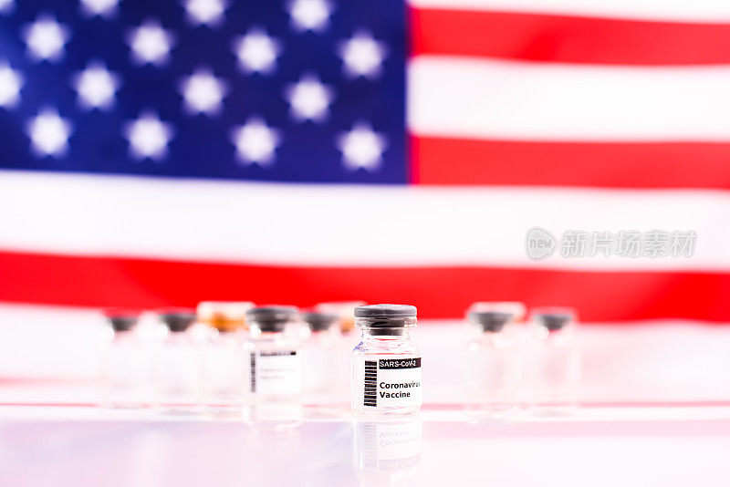 密封的透明小瓶，装着预防冠状病毒引起的新冠肺炎的新疫苗，背景是美国国旗，没有重点。