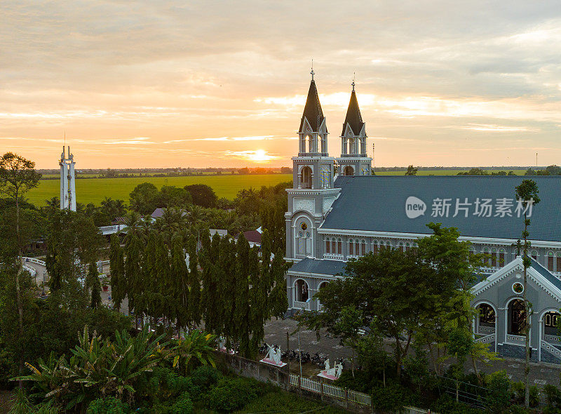 这座教堂坐落在夕阳西下的绿色稻田中，江省