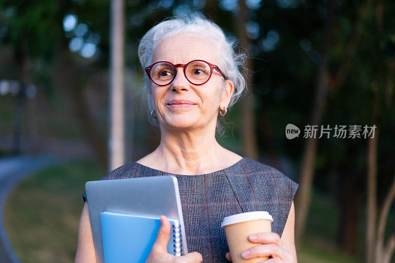 西班牙资深商务女士的肖像，灰白头发，复古眼镜，喝着咖啡。老太太拿着笔记本，蓝色笔记本和咖啡杯