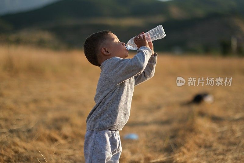 小男孩从瓶子里喝水