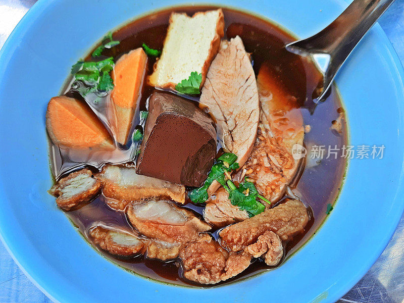 香脆五花肉和水煮蛋的棕色汤面卷——曼谷街头小吃。