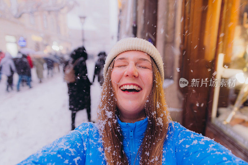 快乐的女性影响者在克拉科夫拍摄自拍，思考下雪的圣诞节