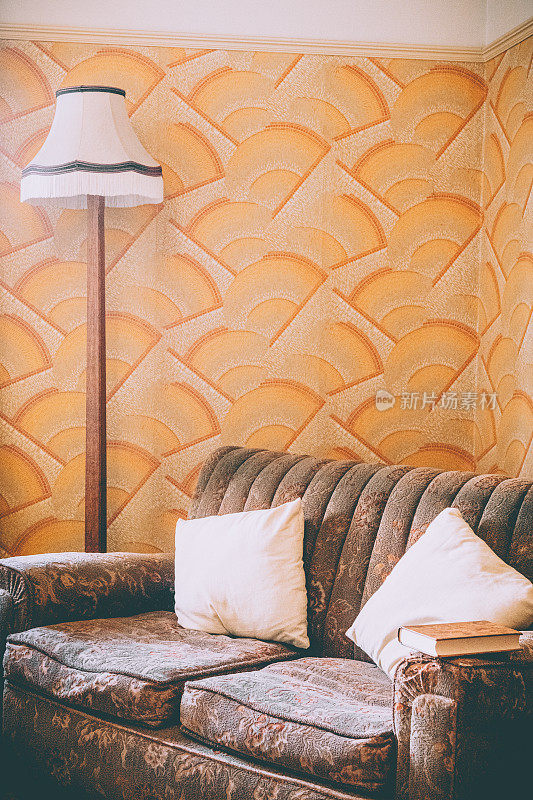 充满活力的客厅有一个时尚的棕色沙发，一个温暖的灯，和纹理壁纸。