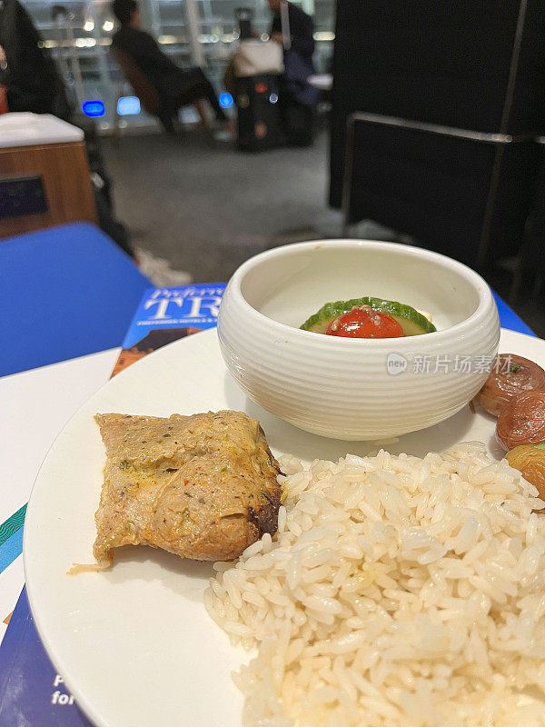 在机场的贵宾休息室享受豪华小吃熟食店:烤鸡、土豆、米饭和沙拉放在盘子里。