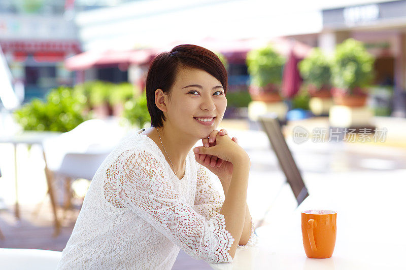 快乐的年轻亚洲女人在咖啡馆