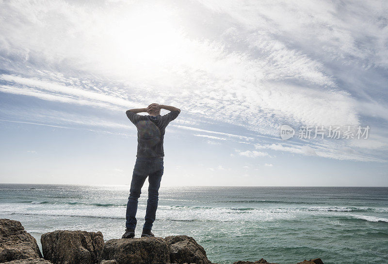 男子站在那里欣赏南康沃尔海岸的景色。