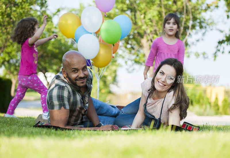 美丽的一家人在野餐时玩气球