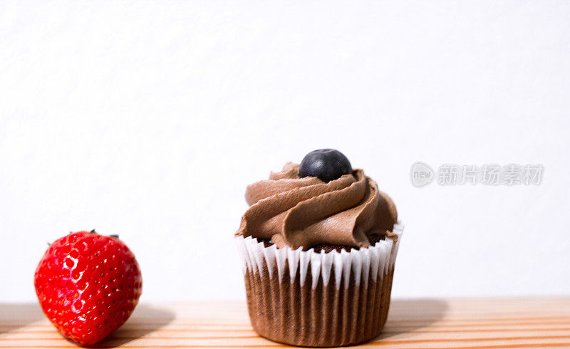 肩并肩:巧克力纸杯蛋糕和草莓静物;白色背景