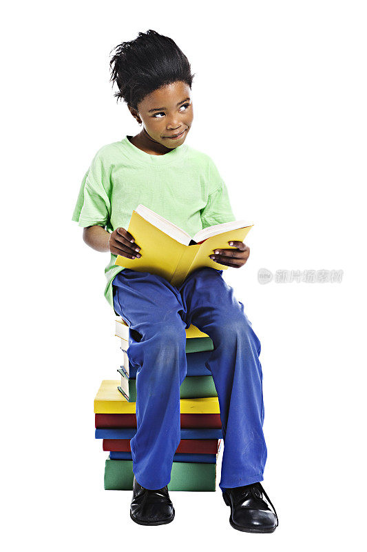 小女孩坐在一堆书上，看书