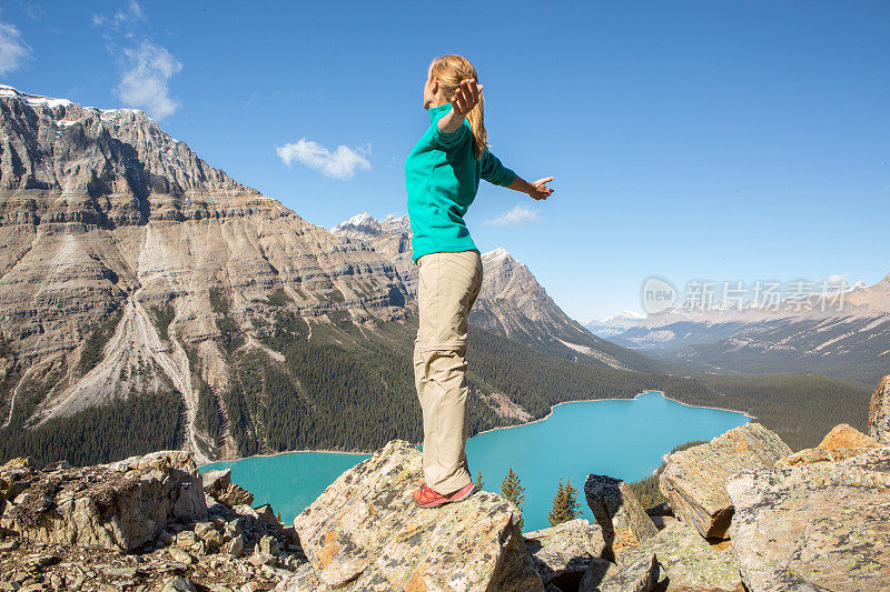 在山顶上欢呼的登山运动员张开双臂