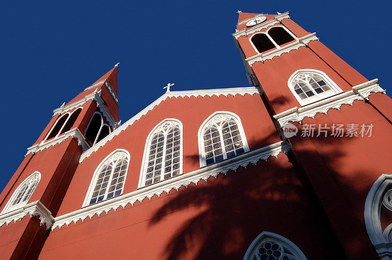 棕榈树的影子映衬着红色的教堂
