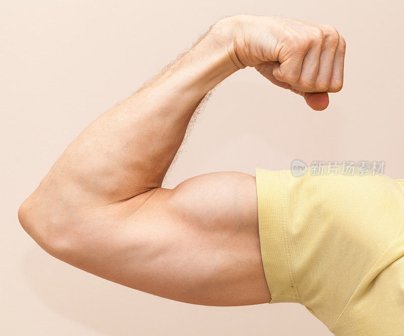 强壮的男性手臂显示二头肌。特写照片