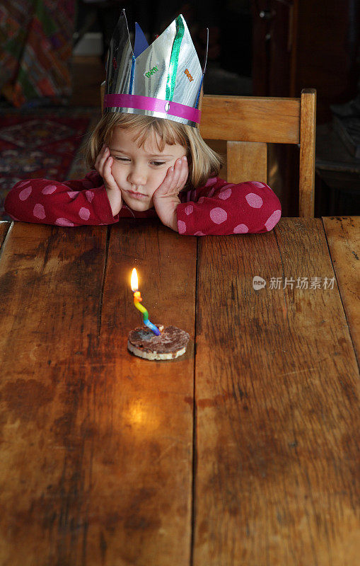 带着派对帽和蜡烛的小女孩