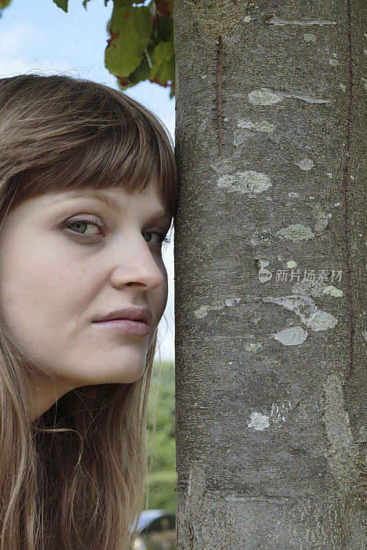 微笑的拉脱维亚树女孩旁边的波斯铁木树