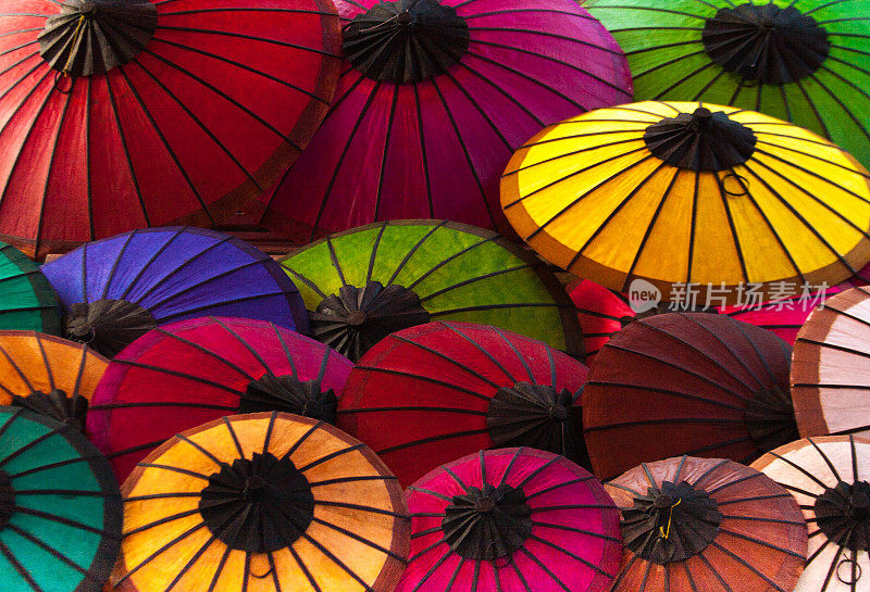 老挝:琅勃拉邦市场上充满活力的彩色纸阳伞