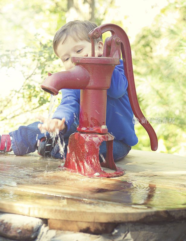 小男孩玩一个古董水泵夜灯